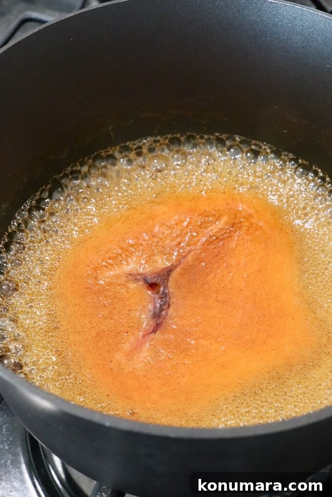 Hot Honey Glazed Chicken Recipe 5 Hot honey sauce bubbling in a pot on the stove