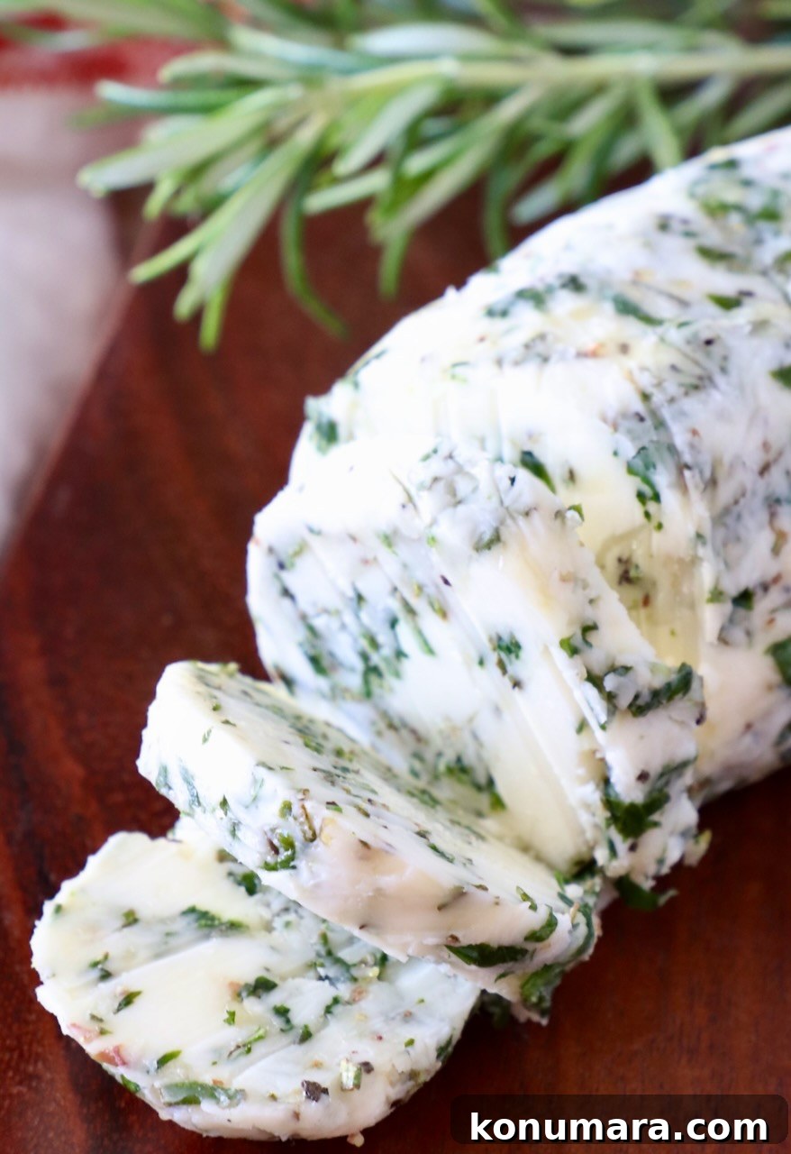 7 Homemade Compound Butter Recipes for Bread, Steak, and Veggies 9 sliced herb butter on a wood cutting board with fresh rosemary