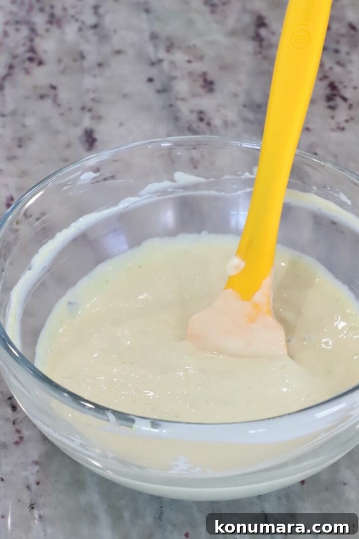 wasabi aioli mixed together in a small glass bowl with a yellow spatula