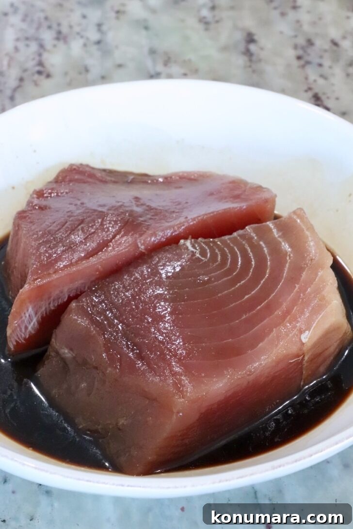 ahi tuna steaks resting in a bowl of soy sauce