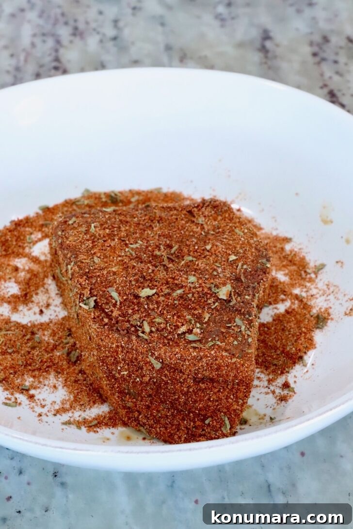 ahi tuna steak seasoned with blackened seasoning in a bowl