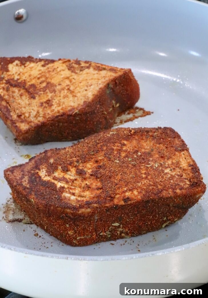 seared blackened seasoned ahi tuna steaks in a skillet