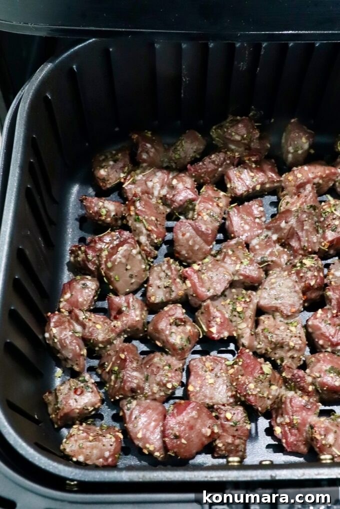Garlic Butter Steak Bites Recipe: Juicy Pan-Seared Bites 8 cooked cubes of steak in an air fryer basket