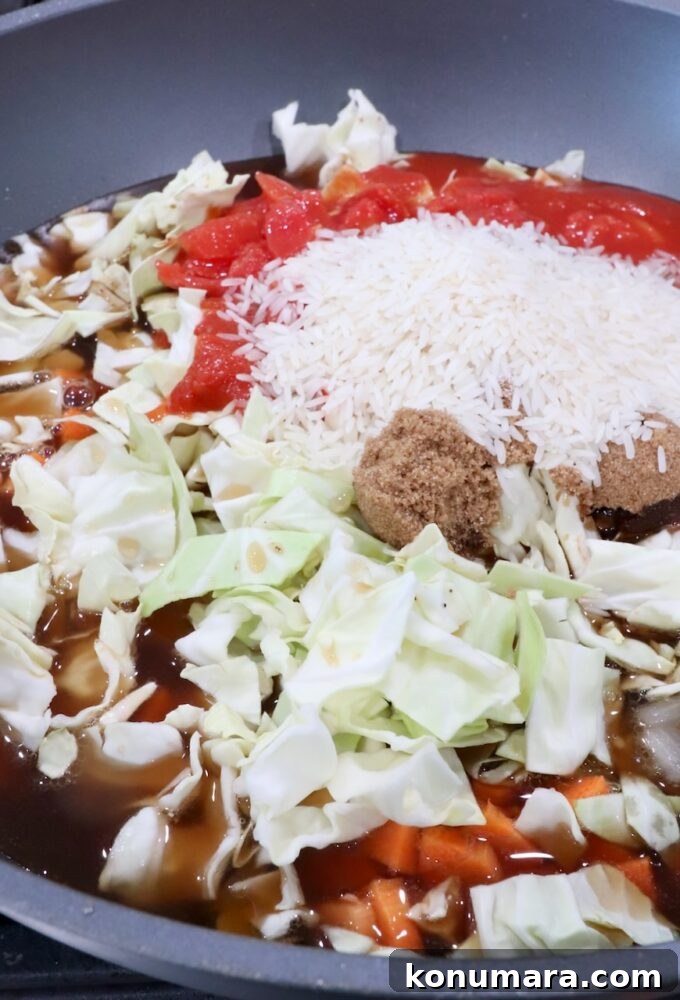 Hearty Cabbage Roll Soup with Savory Tomato Broth 7 chopped cabbage, uncooked white rice and diced tomatoes in a large pot with cooked ground beef and onions
