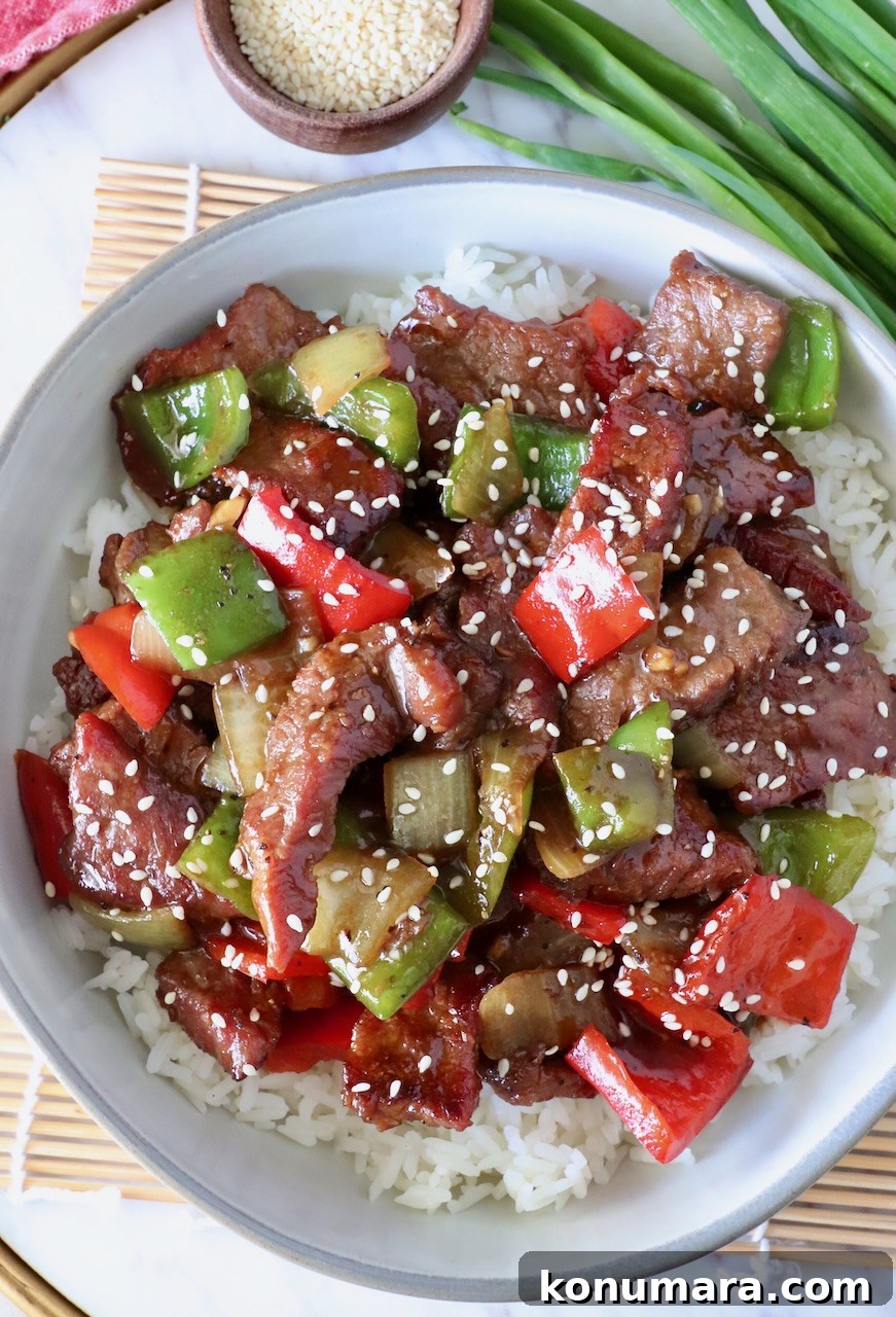 Pepper Steak Stir-Fry Recipe with Bell Peppers 11 prepared pepper steak on top of cooked white rice in a bowl