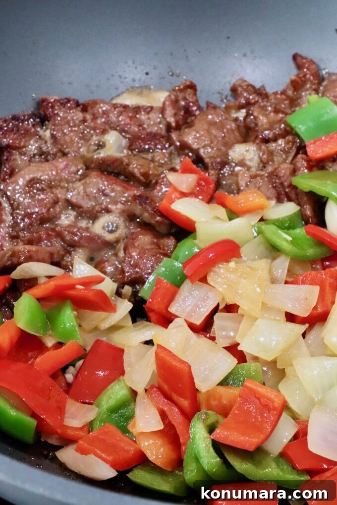 Pepper Steak Stir-Fry Recipe with Bell Peppers 8 cooked beef, diced bell peppers and onions in a large wok