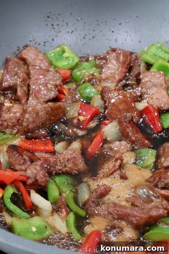 Pepper Steak Stir-Fry Recipe with Bell Peppers 9 cooked beef, diced bell peppers and onions mixed together in a large wok with sauce