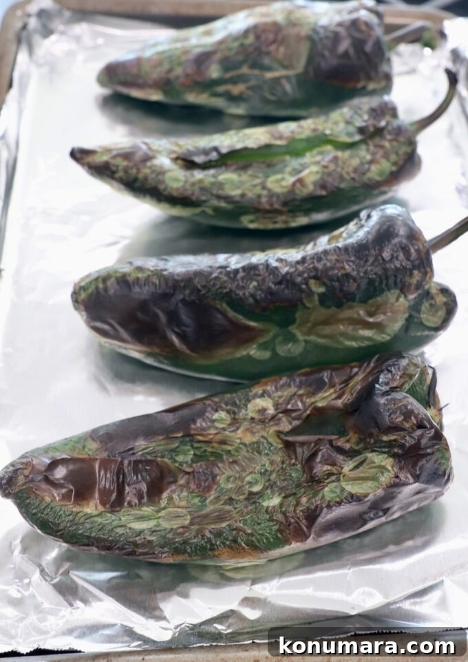 roasted poblano peppers on foil lined baking sheet