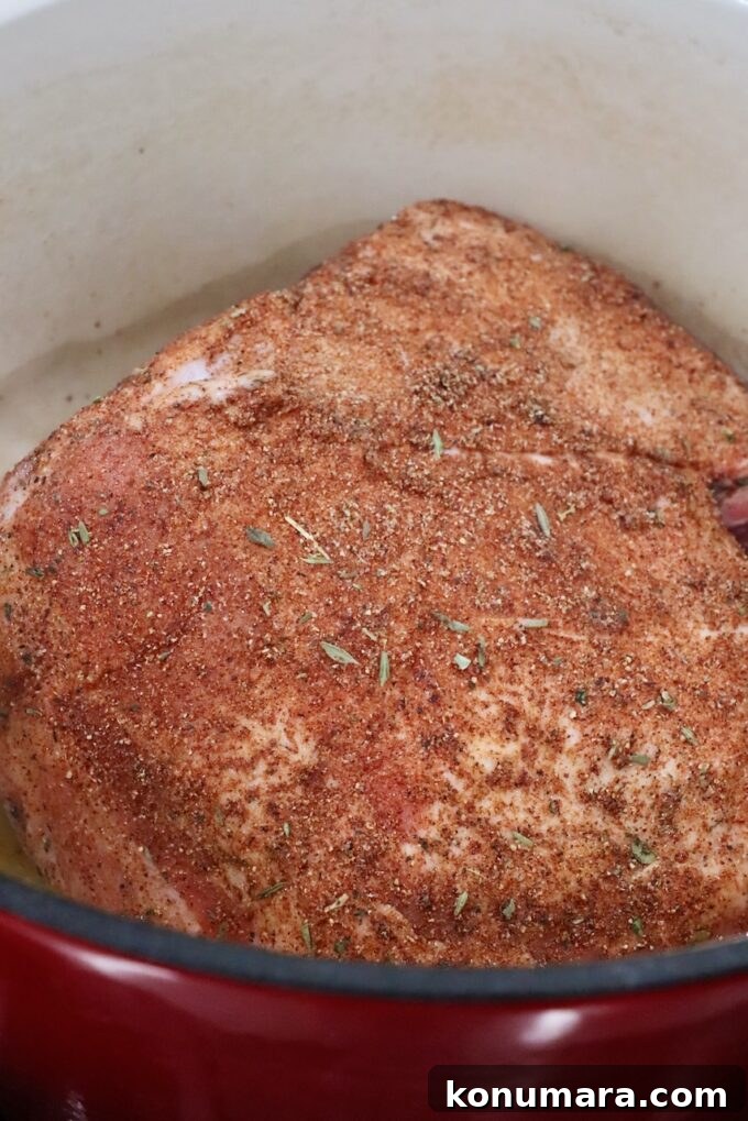 seasoned pork shoulder in a large cast iron pot