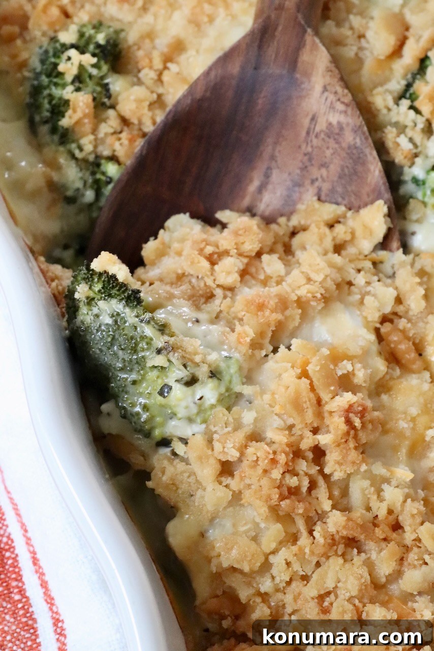 creamy casserole topped with a cracker topping in a casserole dish with a serving spoon