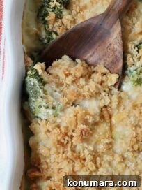 baked casserole with a cracker topping in a baking dish with a serving spoon