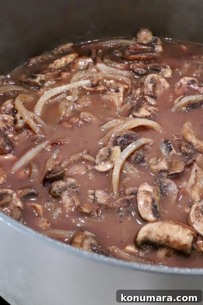 How to Make Chopped Steak with Mushroom Gravy 12 sliced onions and mushrooms in a red wine gravy in a large pot