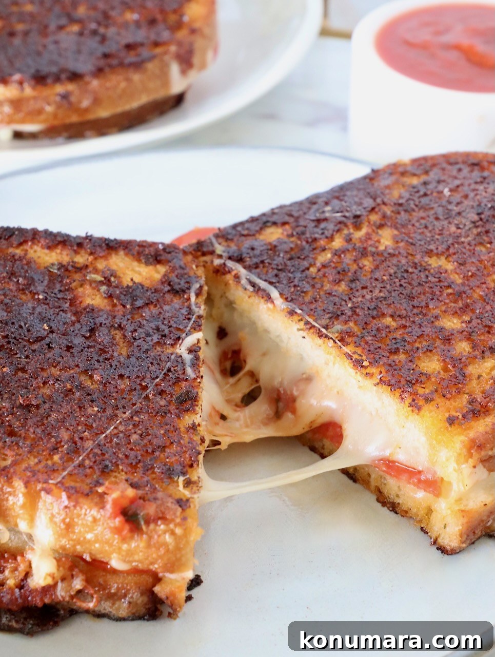 pizza grilled cheese cut in half and pulled apart on a plate