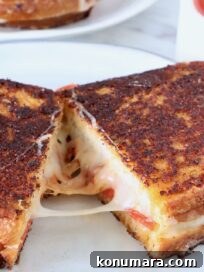 Pepperoni Pizza Grilled Cheese Recipe 16 pizza grilled cheese sandwich cut in half and pulled apart on a plate