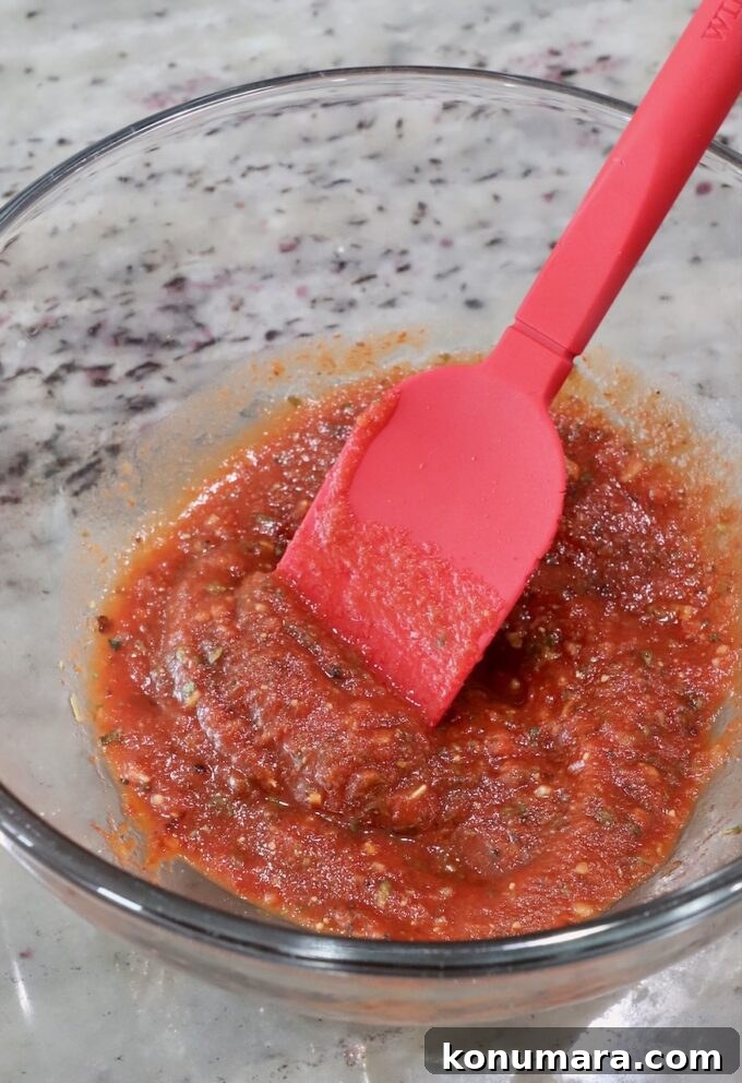 Pepperoni Pizza Grilled Cheese Recipe 5 seasoned pizza sauce in a glass bowl with a red spatula