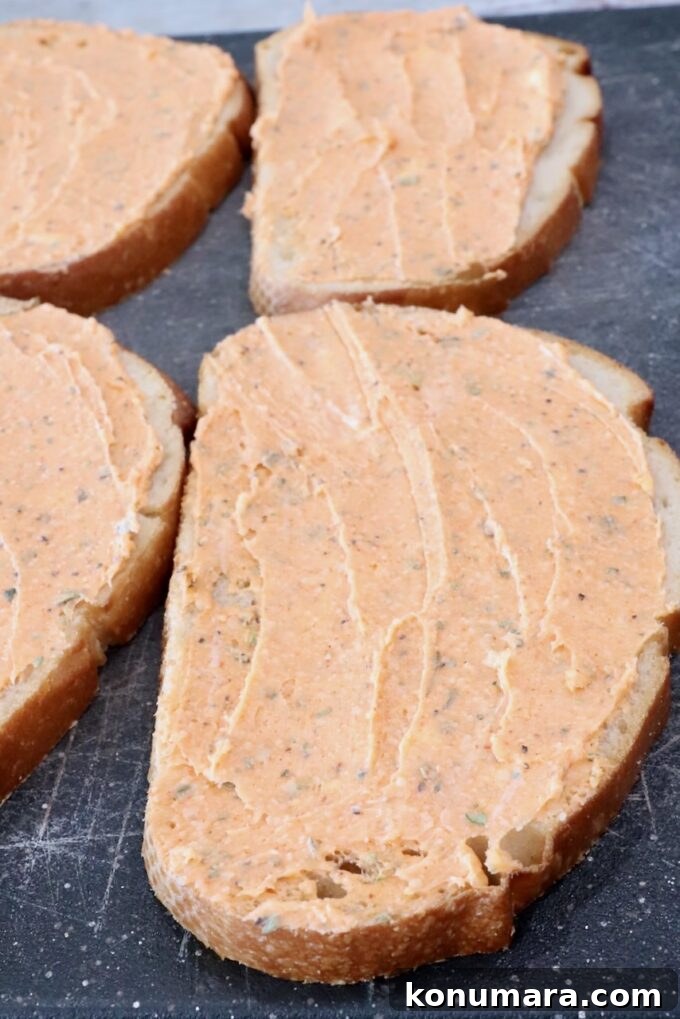 Pepperoni Pizza Grilled Cheese Recipe 6 seasoned butter spread on sliced bread on a cutting board
