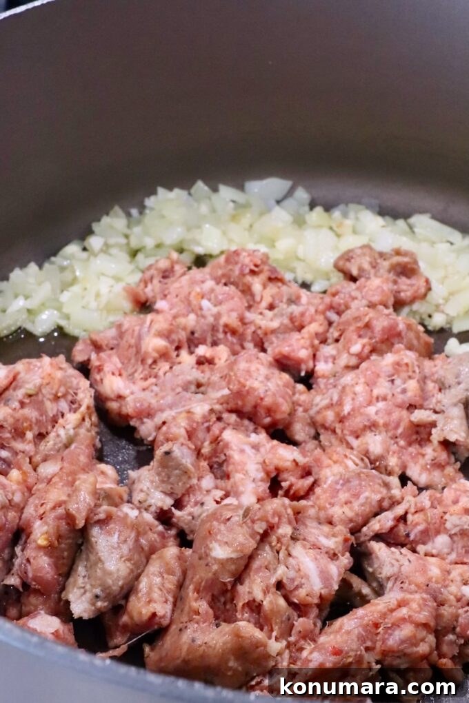 diced onion in a large pot with loose Italian sausage