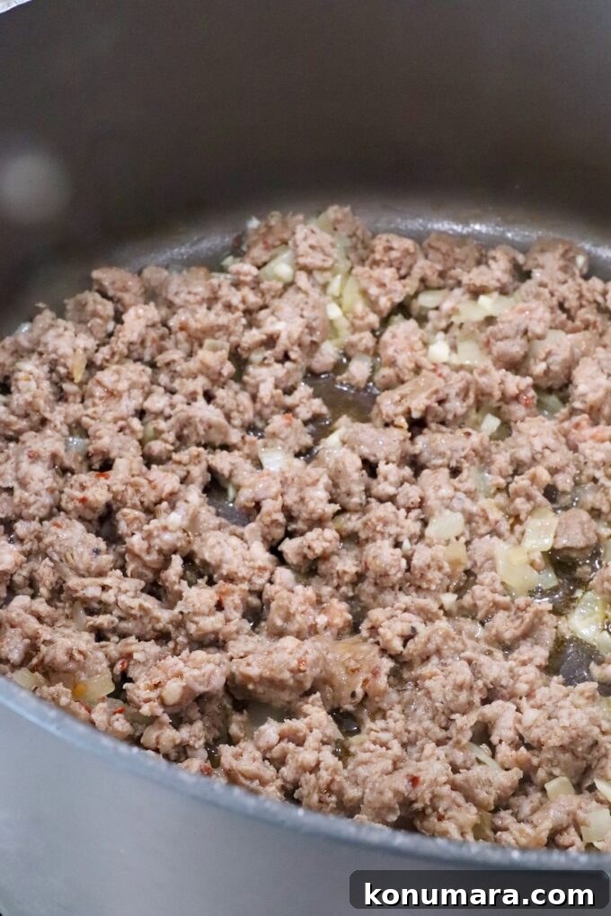 cooked sausage and onions in a large pot