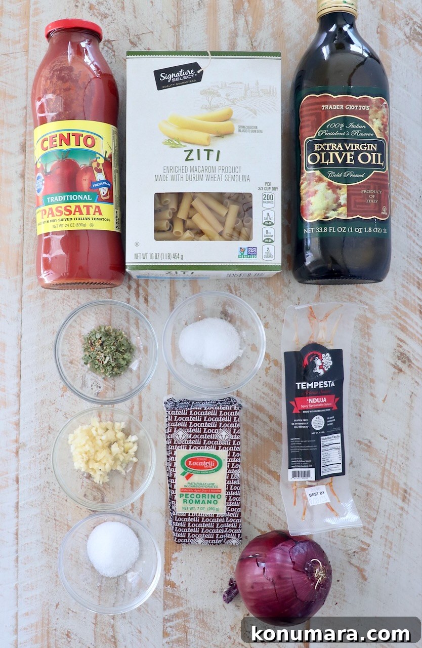 ingredients for nduja tomato sauce on a white wood board