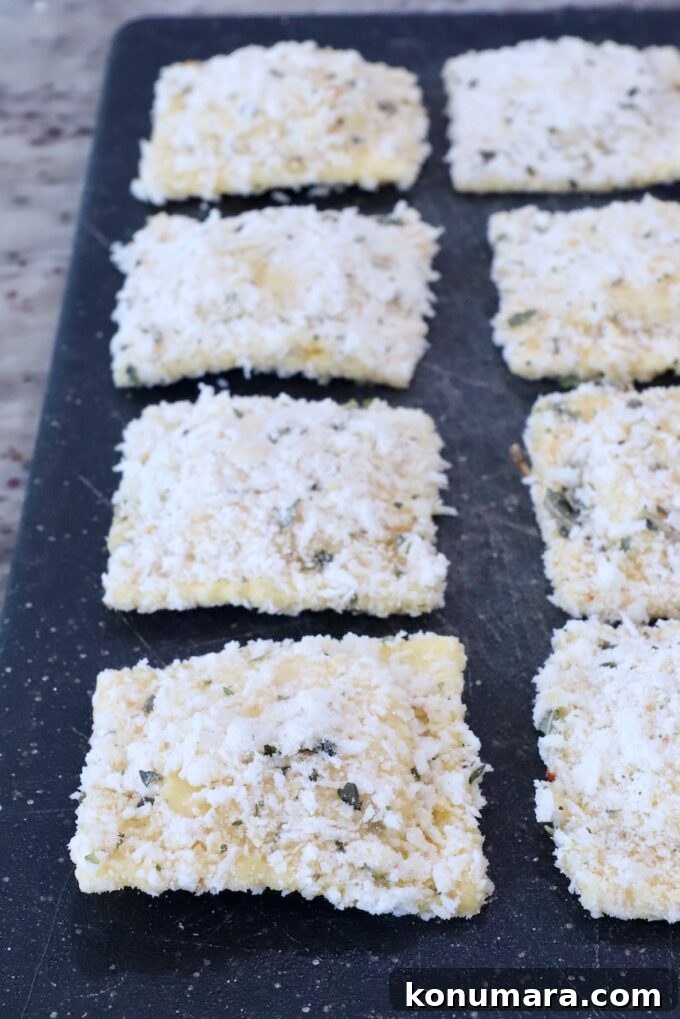 raviolis coated in breadcrumbs on a cutting board