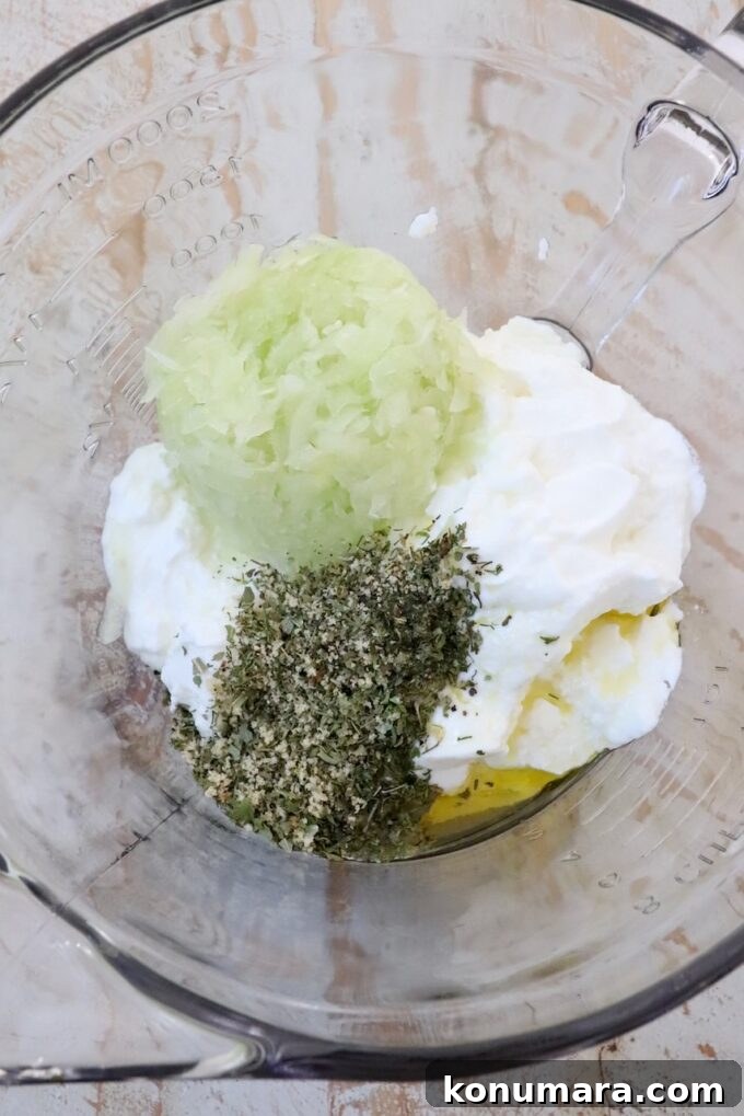yogurt, grated cucumber, oil and dried herbs and spices in a large glass bowl