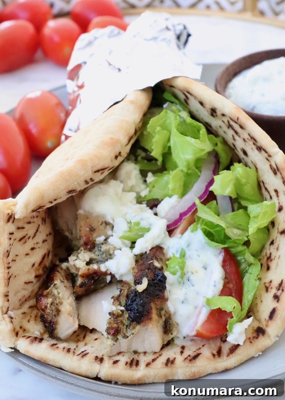 Homemade Greek Chicken Gyros Recipe 2 cooked chicken gyro meat in a piece of pita bread with lettuce, tomato and tzatziki sauce