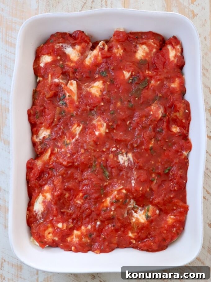 Ricotta Stuffed Shells Recipe with Spinach 8 stuffed shells topped with marinara sauce in a casserole dish
