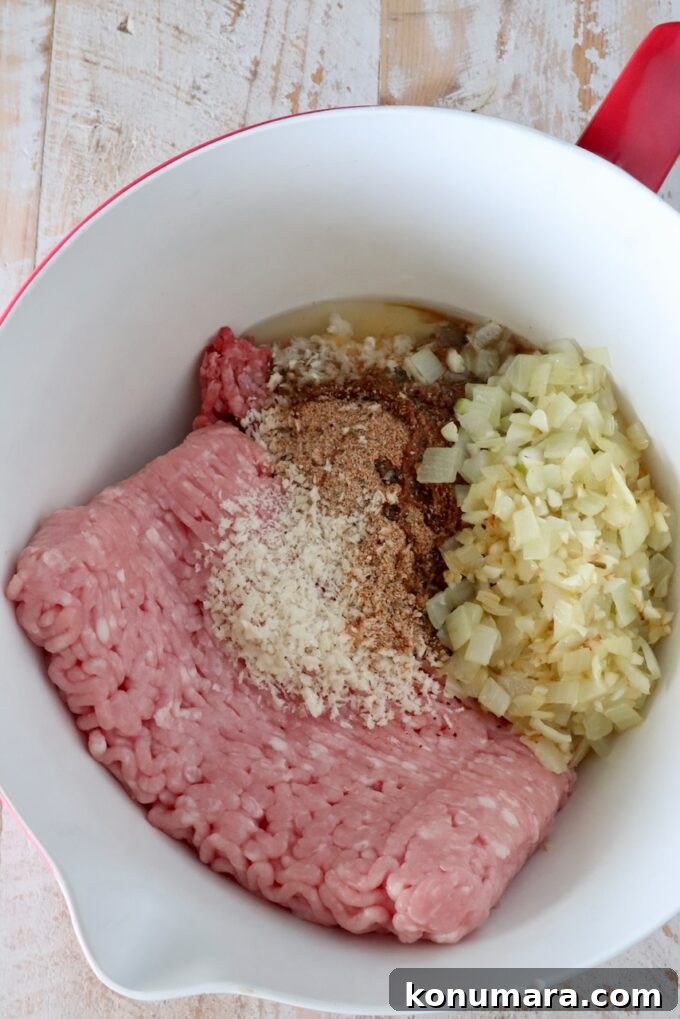30-Minute Air Fryer Meatloaf Recipe with Crispy Edges 4 raw ground beef and ground pork in a large mixing bowl with breadcrumbs, cooked onions, and spices