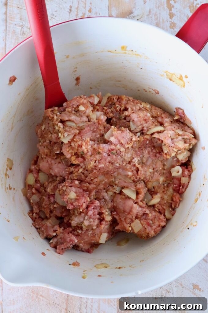 30-Minute Air Fryer Meatloaf Recipe with Crispy Edges 5 meatloaf mixture combined in a mixing bowl with a red spatula