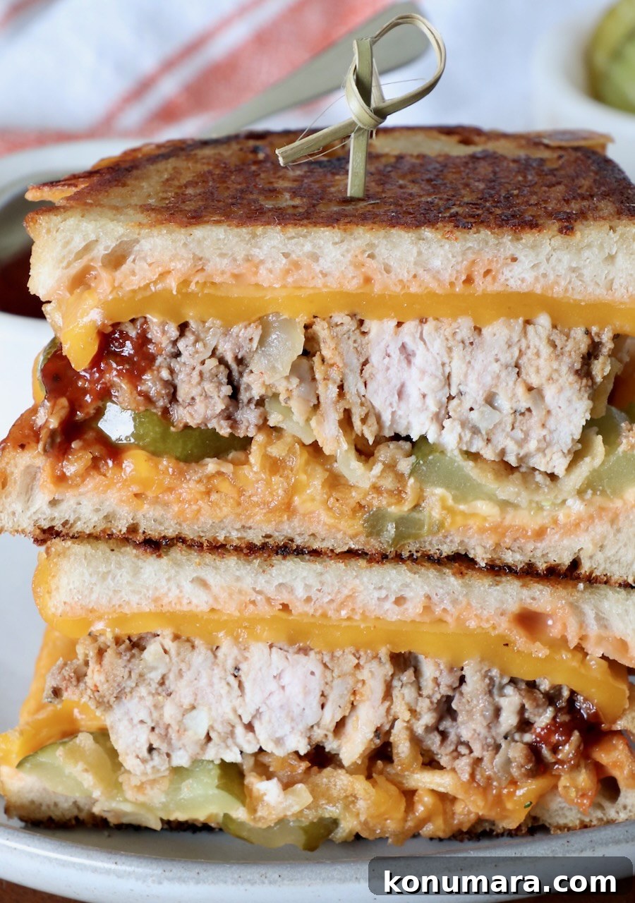 How to Make a Classic Meatloaf Sandwich 10 meatloaf sandwich sliced in half and stacked up on top of each other on a plate with a wooden skewer stuck in the top of the sandwich