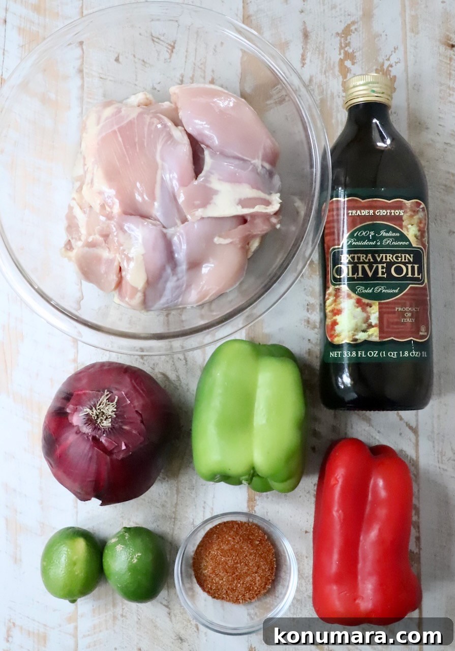 ingredients for air fryer chicken fajitas on a white wood board
