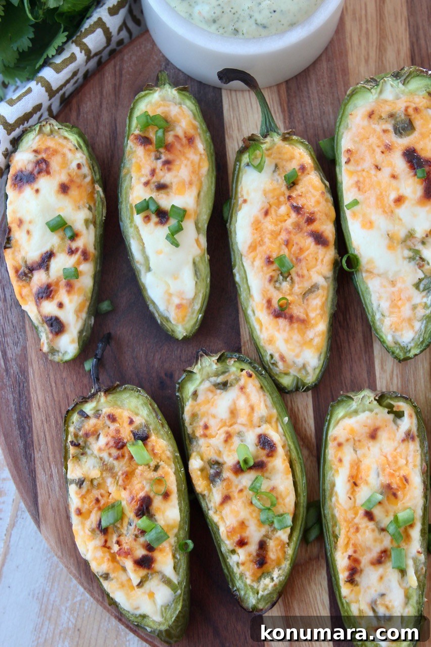 Smoky Grilled Jalapeno Poppers Recipe with Cream Cheese 8 grilled jalapeno poppers on wood cutting board