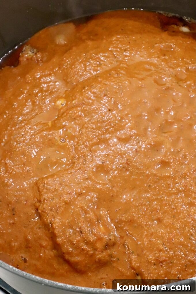 Classic Mexican Chicken Adobo Recipe 7 chicken thighs covered in adobo sauce in a large dutch oven