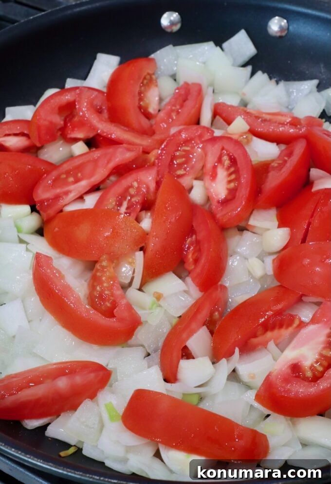 Classic Mexican Chicken Adobo Recipe 4 diced onions and sliced tomatoes in a skillet
