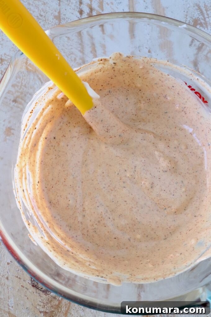 creamy chili lime dressing in a glass bowl with a yellow spatula