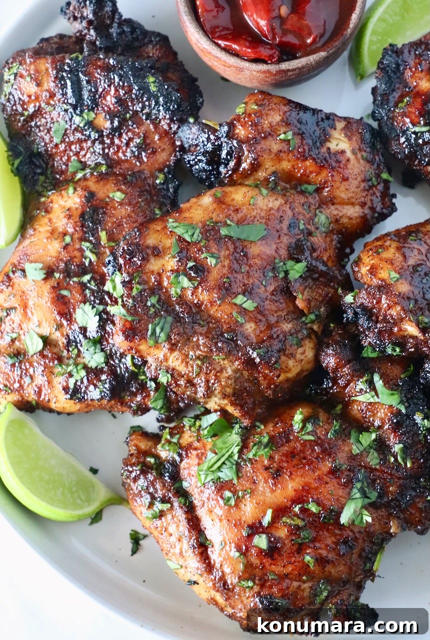 Chipotle Honey Glazed Chicken Recipe 2 Glazed grilled chicken thighs stacked on a plate with cilantro and lime wedges
