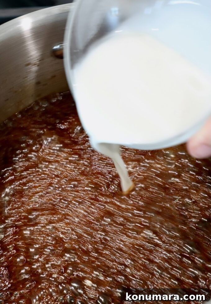 Authentic Korean BBQ Sauce for Bulgogi and Galbi 5 cornstarch slurry poured from a small glass bowl into simmering sauce in a pot