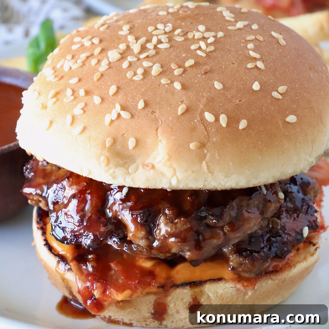 Korean BBQ Burger with Gochujang Glaze and Kimchi Slaw 10 prepared burger on a plate with korean bbq sauce