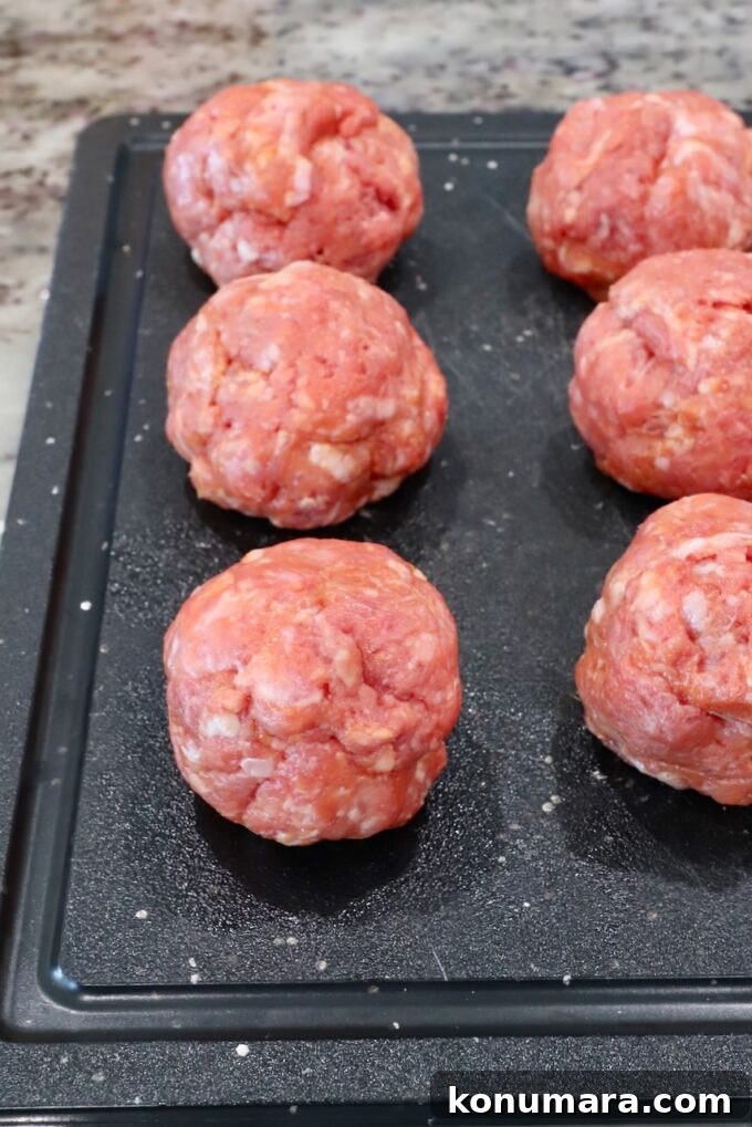 Korean BBQ Burger with Gochujang Glaze and Kimchi Slaw 5 balls of seasoned ground beef and pork on a cutting board