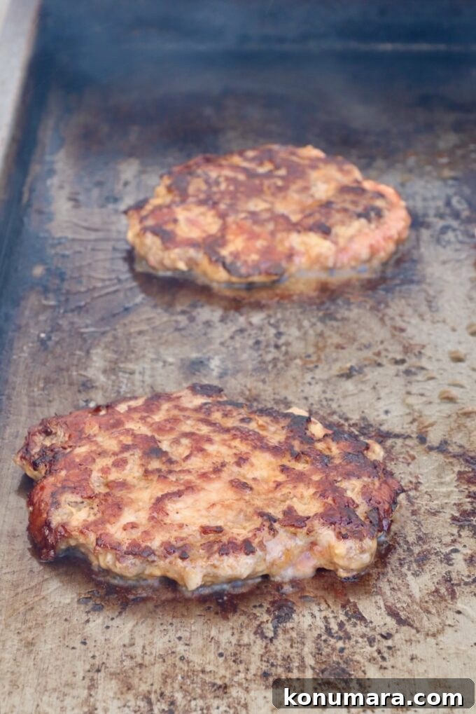 Korean BBQ Burger with Gochujang Glaze and Kimchi Slaw 7 grilled burger patties on a griddle