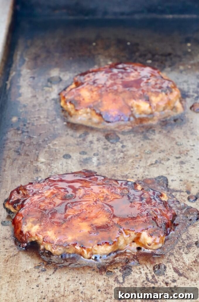 Korean BBQ Burger with Gochujang Glaze and Kimchi Slaw 8 burger patties topped with korean bbq sauce on a griddle