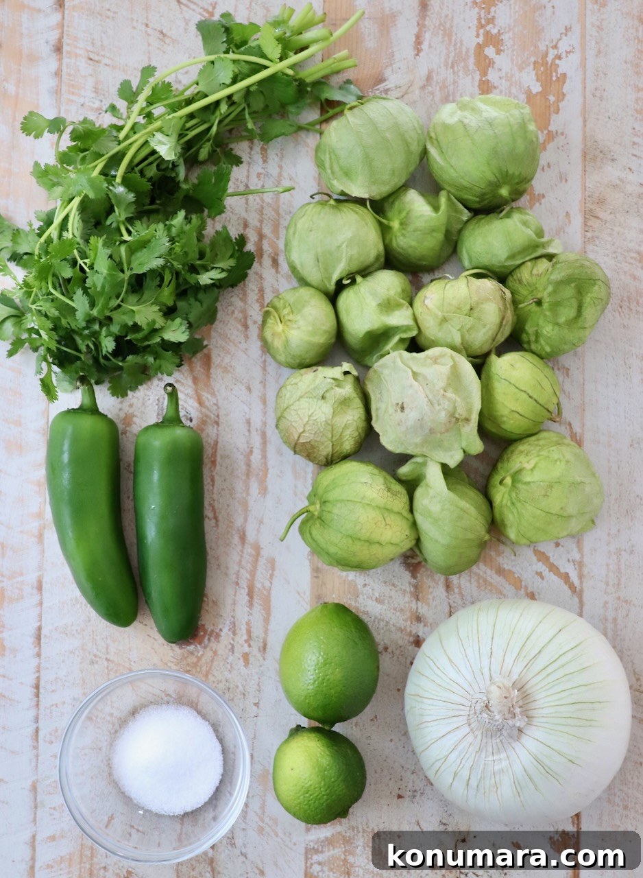ingredients for tomatillo salsa on a white wood board