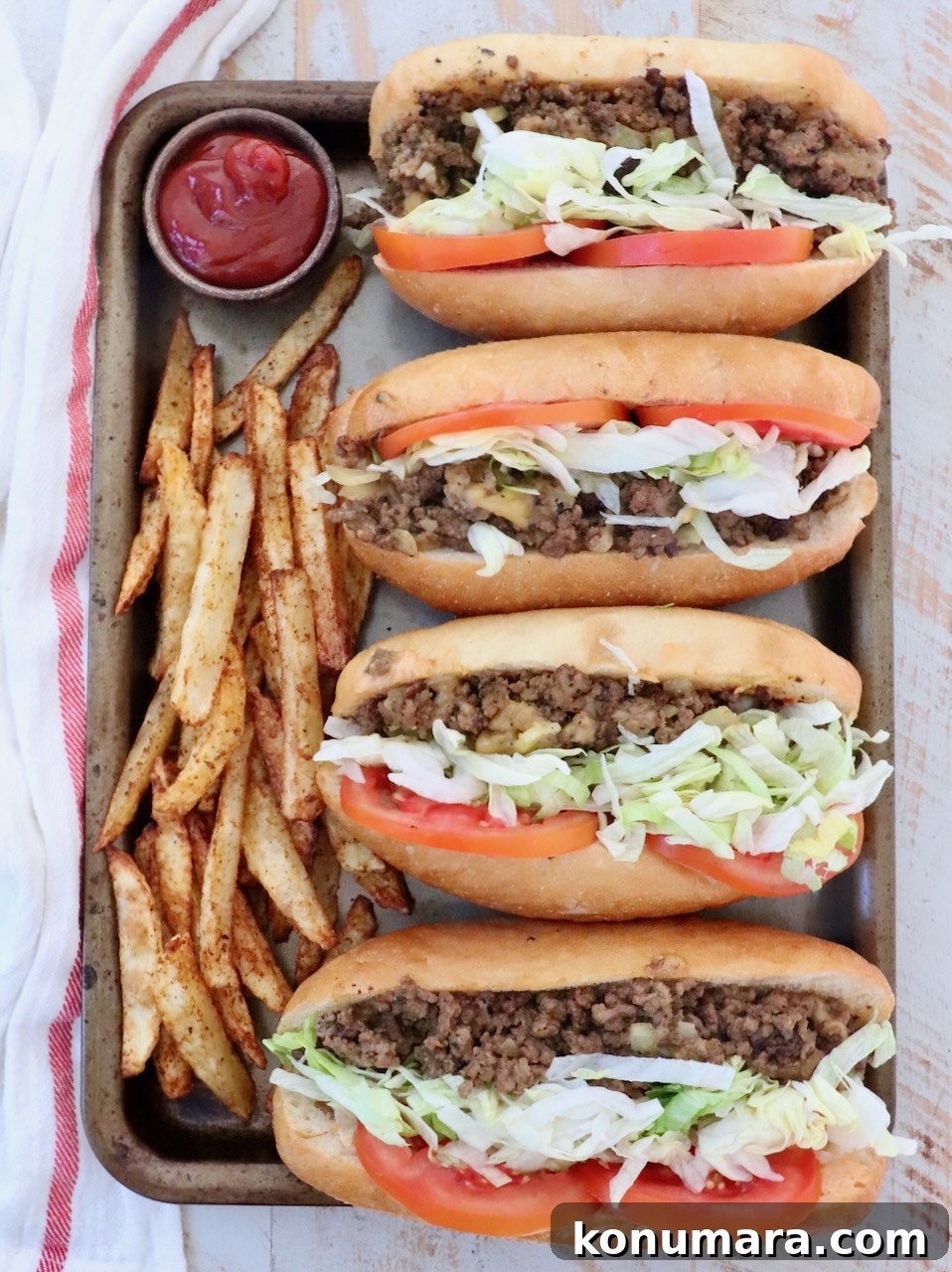 New York Bodega Chopped Cheese Sandwich Recipe 2 four chopped cheese sandwiches on a baking sheet with cooked fresh fries and a small bowl of ketchup