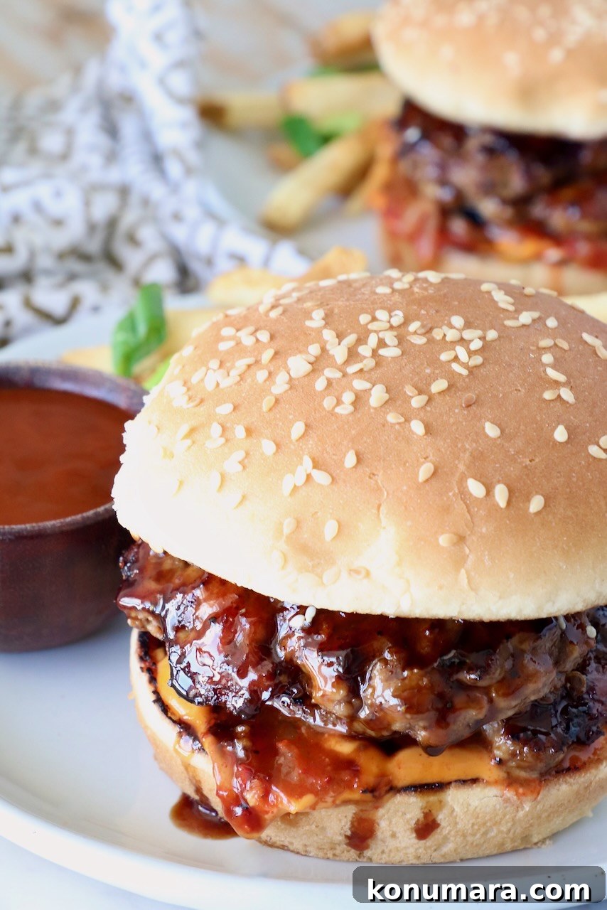 prepared burger on a plate with korean bbq sauce and french fries
