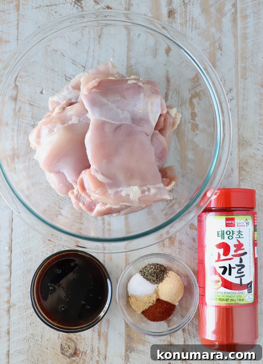Korean BBQ Chicken with Gochujang Glaze 3 ingredients for korean bbq chicken in glass bowls on a white wood board