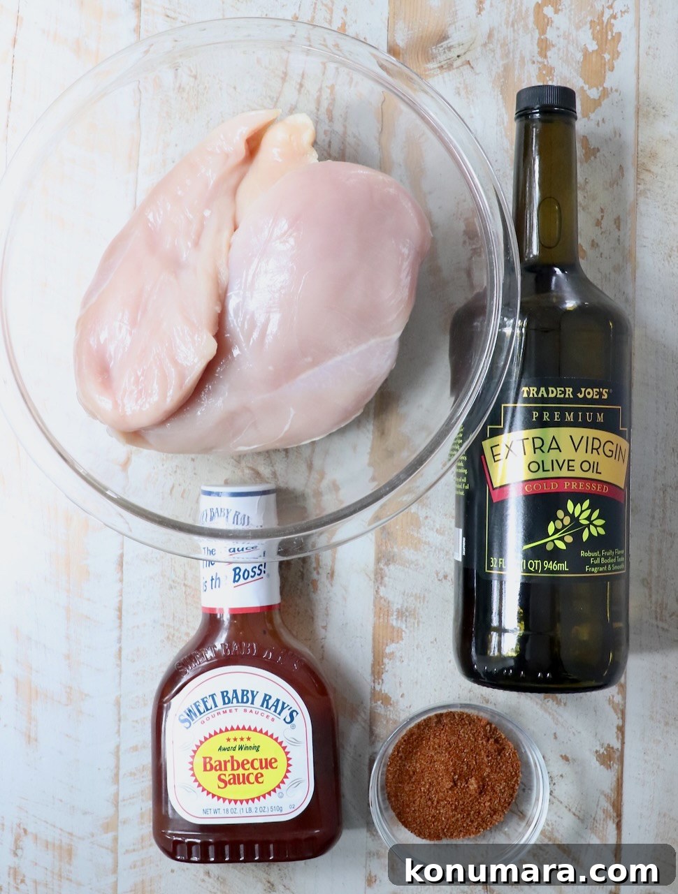 ingredients for smoked chicken breasts on a white wood board