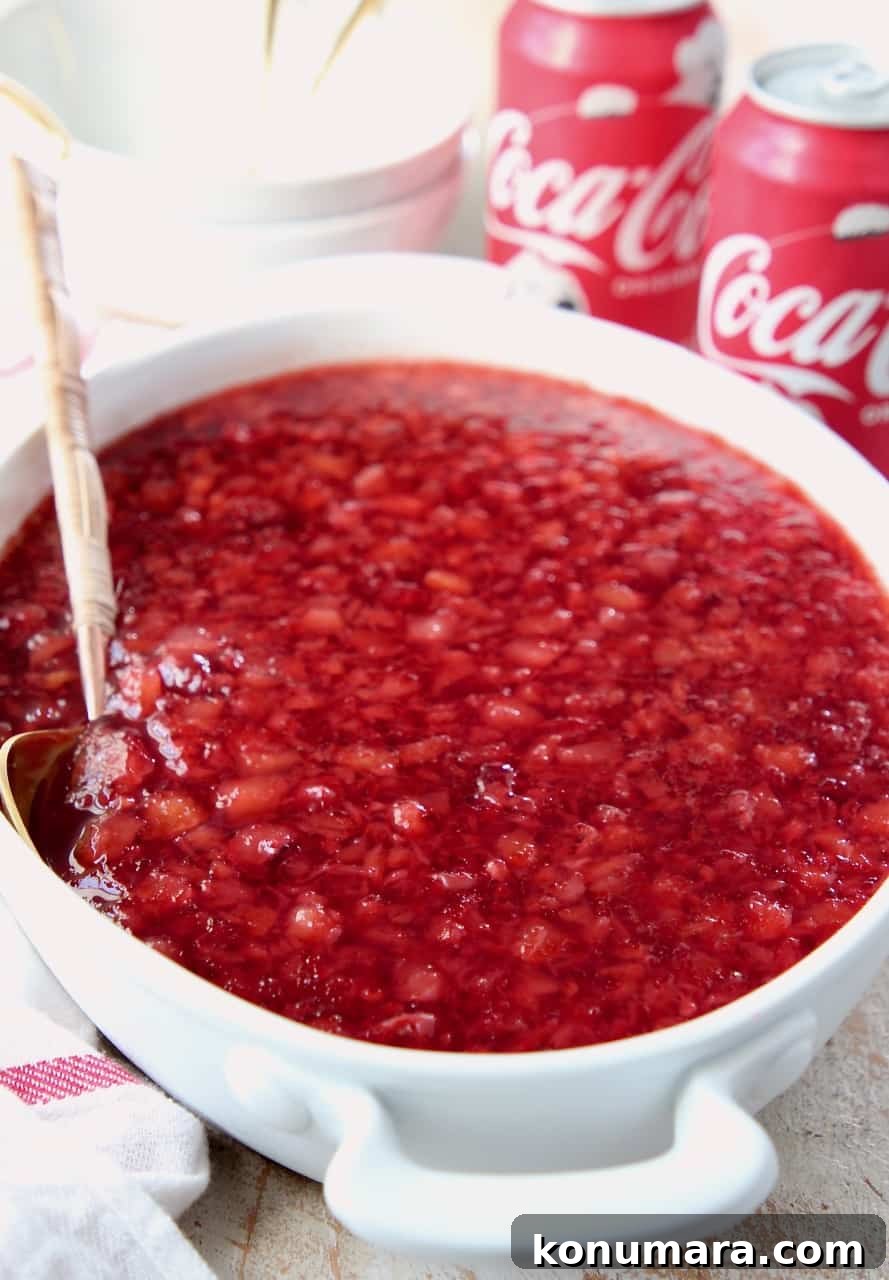 cherry jello salad in white serving dish with spoon