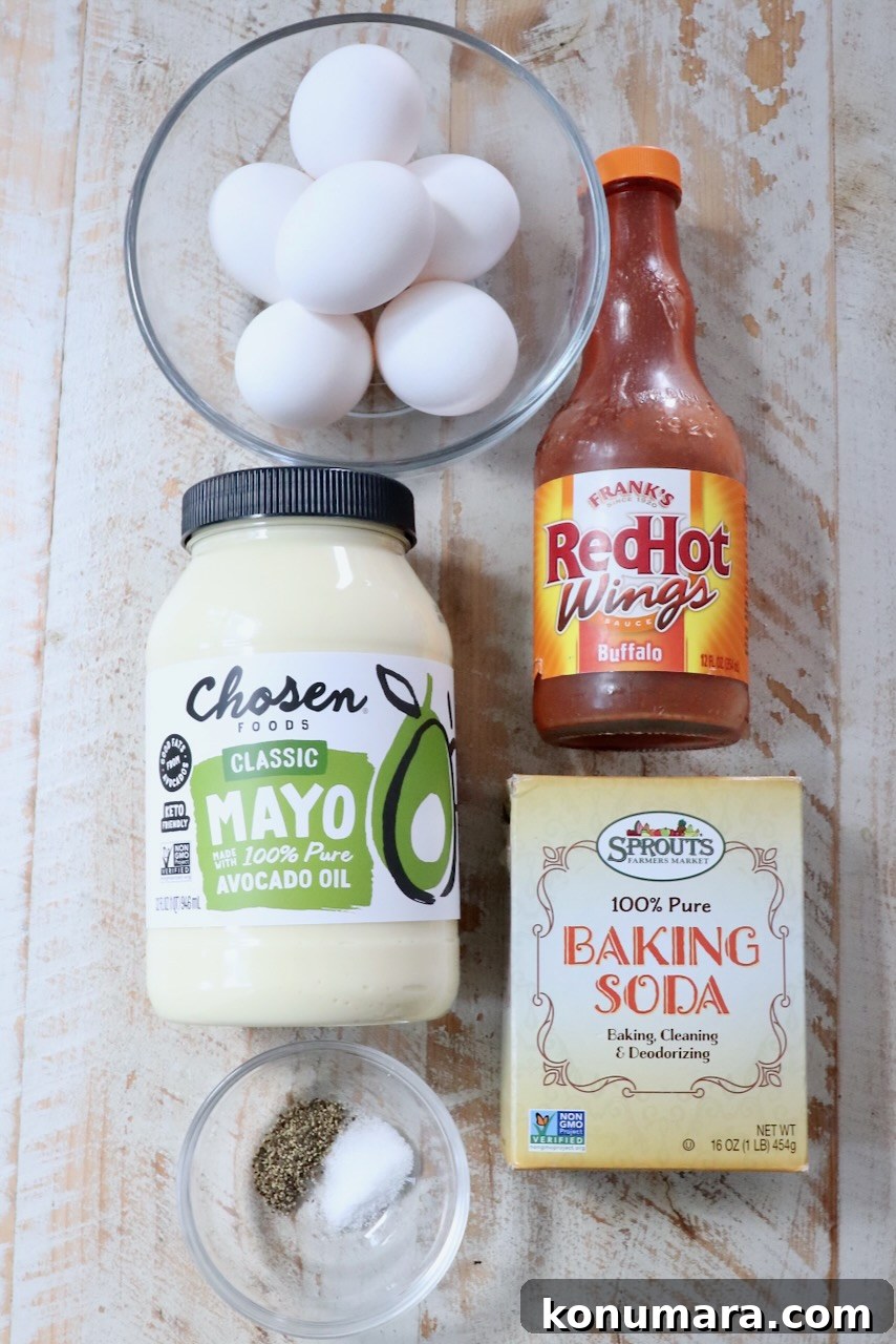 Spicy Buffalo Deviled Eggs Recipe for Game Day 3 Ingredients for buffalo deviled eggs arranged on a white wood board