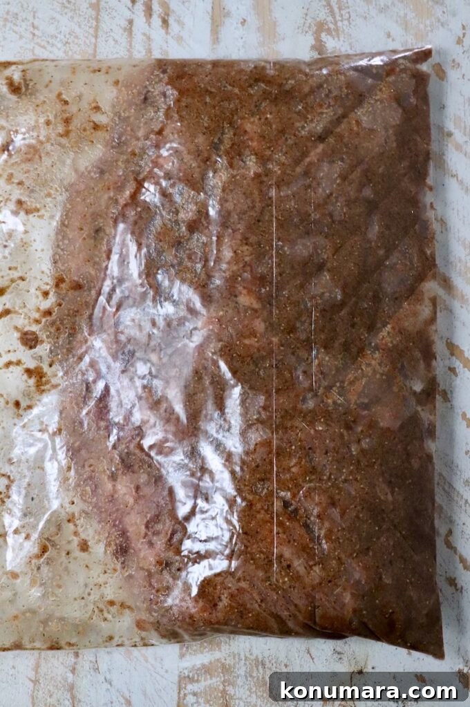 skirt steak marinating in shawarma seasoning in a large plastic zipper bag