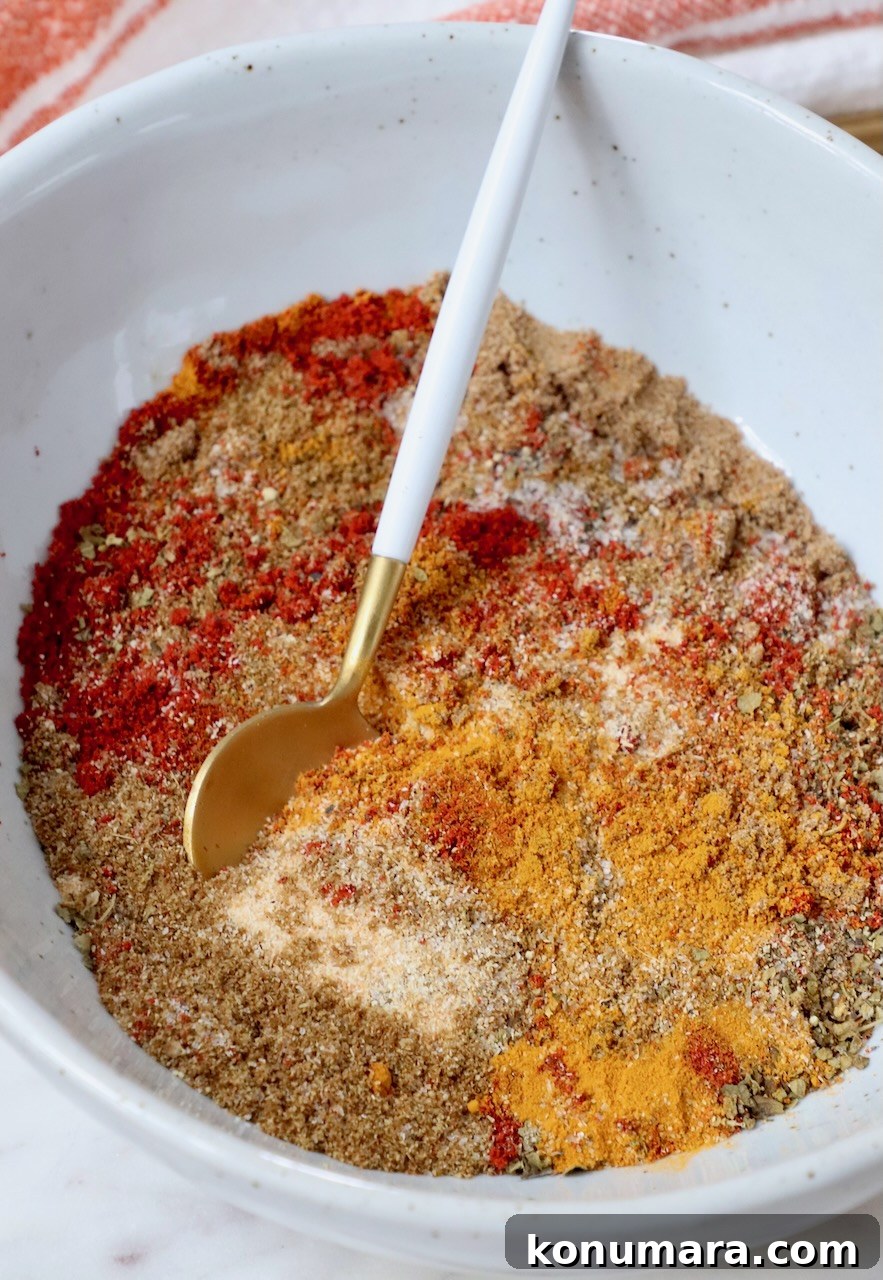 spices mixed together in a bowl with a small spoon